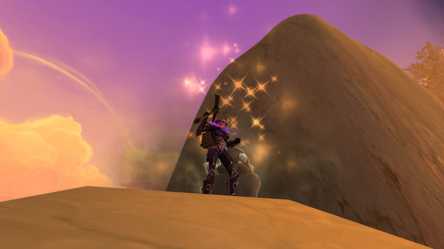 A lone traveler resting beside a boulder at golden hour
